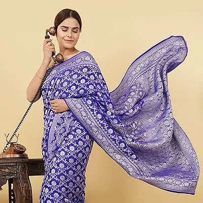 Ckstudio shot of woman wearing blue patterned saree with flowing pallu on beige background — Garment Photography