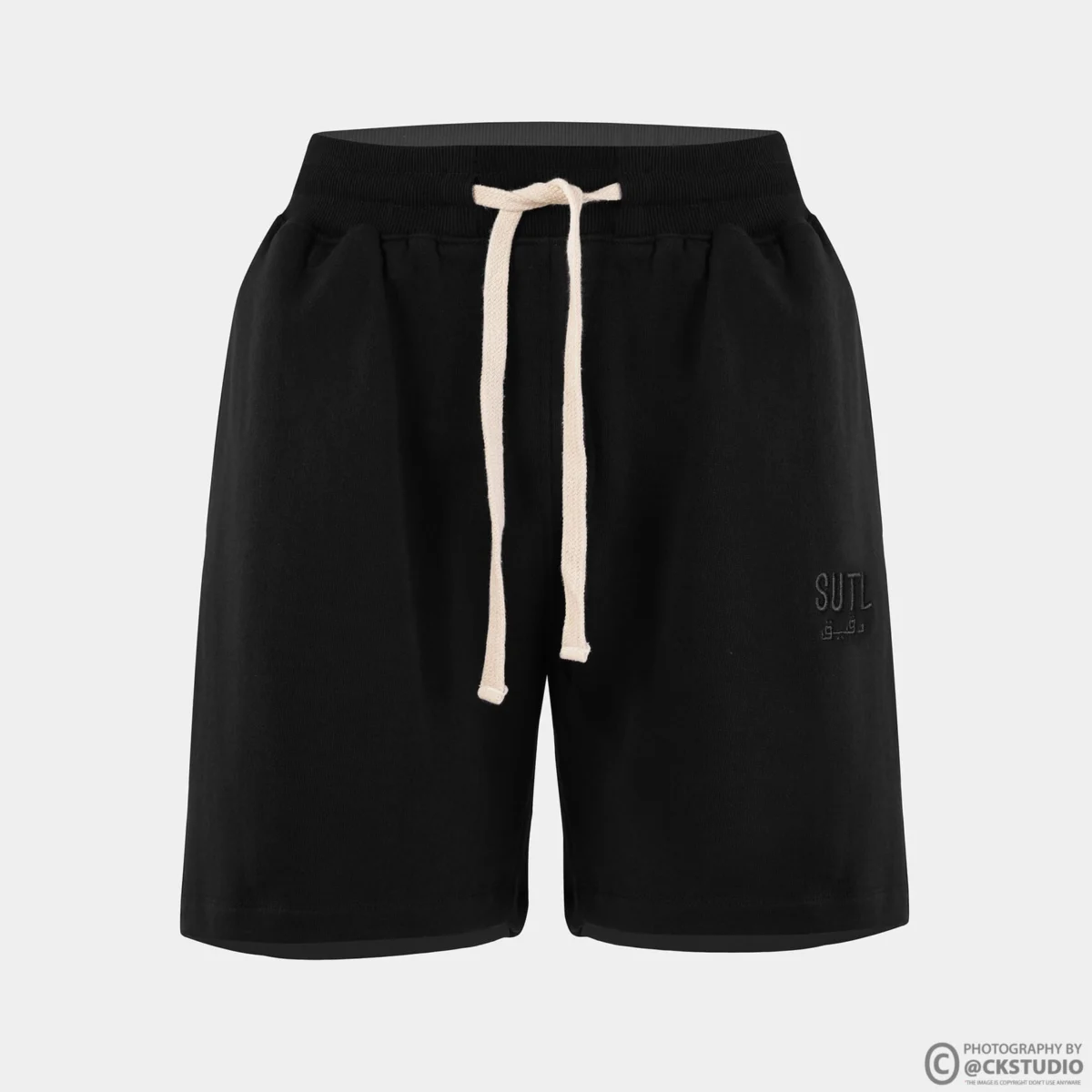 Ghost mannequin catalogue photograph of black drawstring shorts on a pure white background showing waistband shape and leg opening