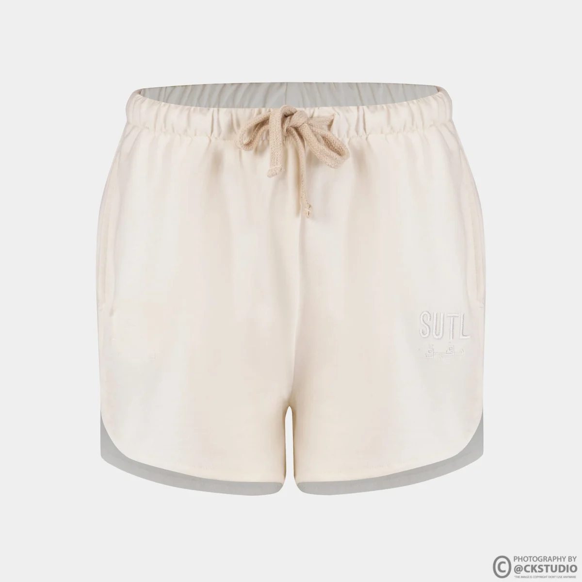 Cream drawstring lounge shorts photographed in ghost mannequin style on a light grey background, showing waistband, side seams and hem for a bottomwear listing