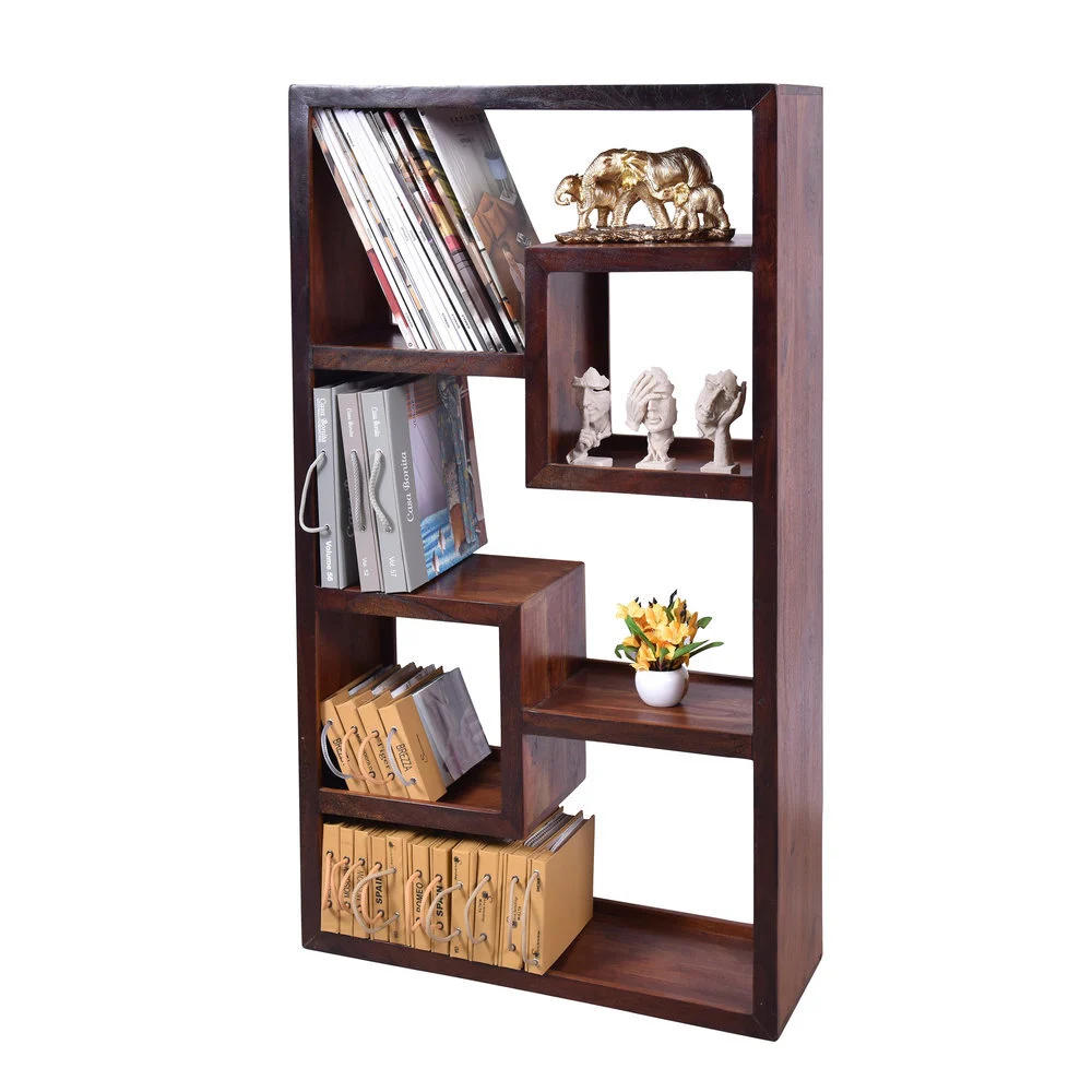Dark wood open bookshelf with staggered compartments styled with books, magazines and small decor figures, shot on white to show how light styling explains use without hiding the shelves
