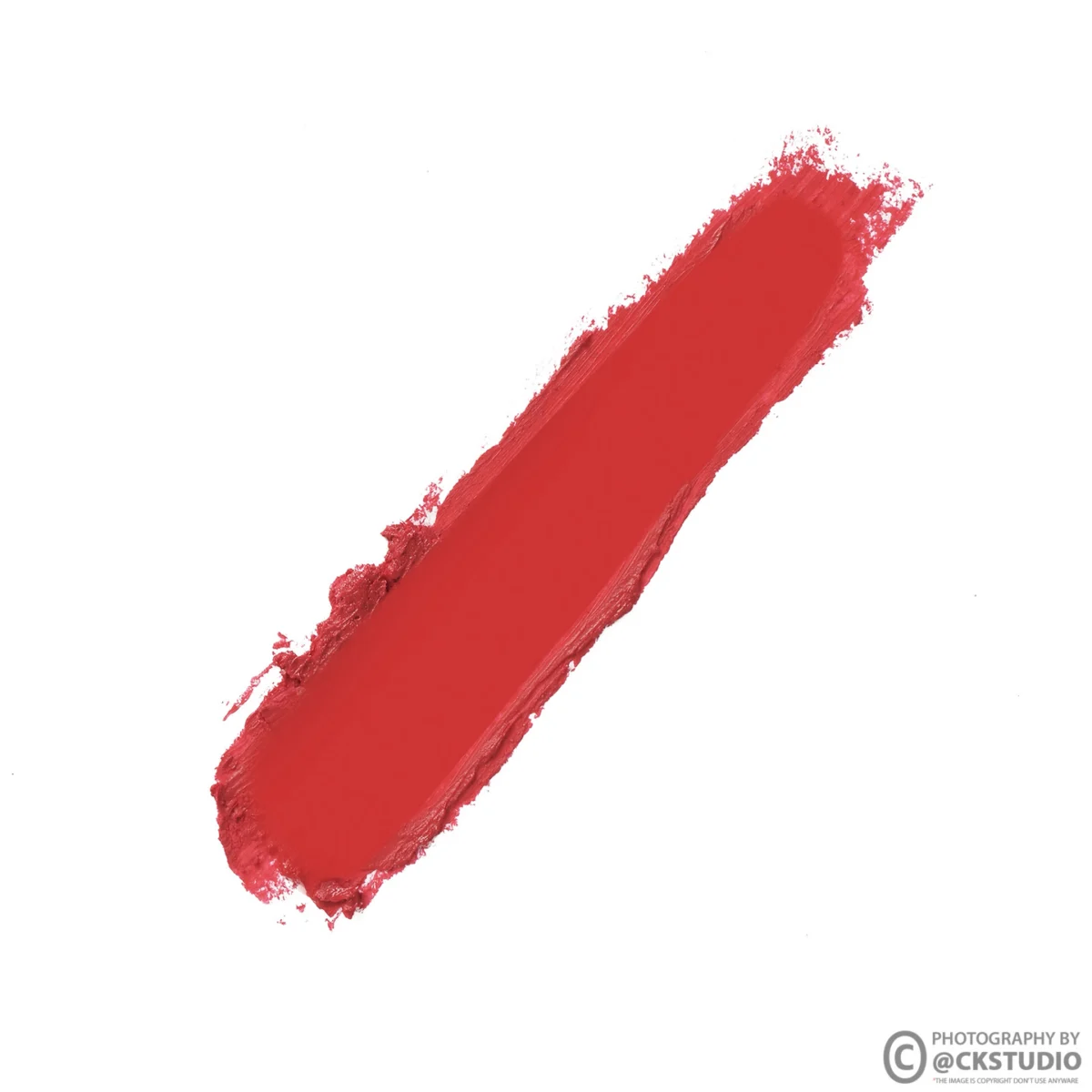 Single bold red lipstick swatch smeared diagonally across a plain white card, showing true colour and creamy texture for a shade comparison image