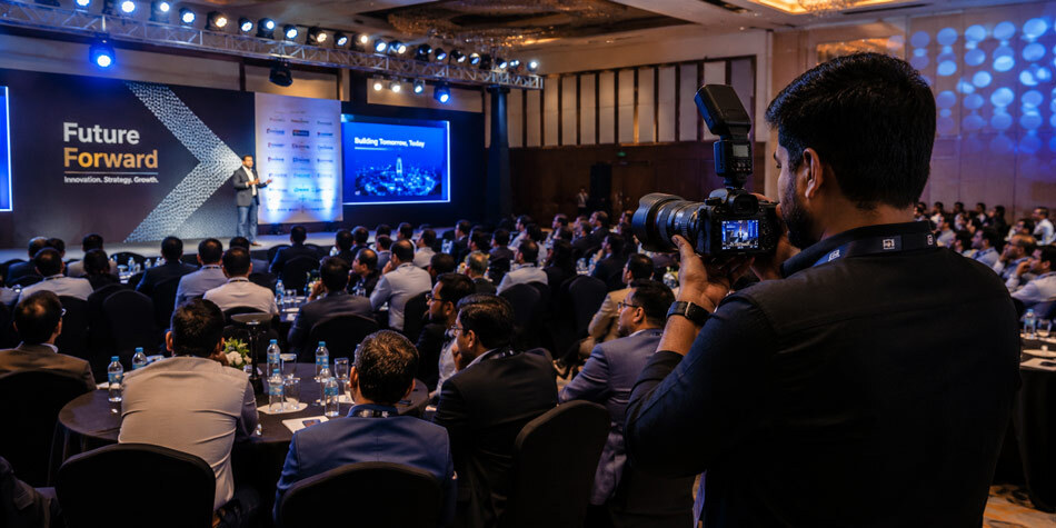 Professional corporate event photography of an Indian business conference with audience engagement and stage lighting captured by Ckstudio