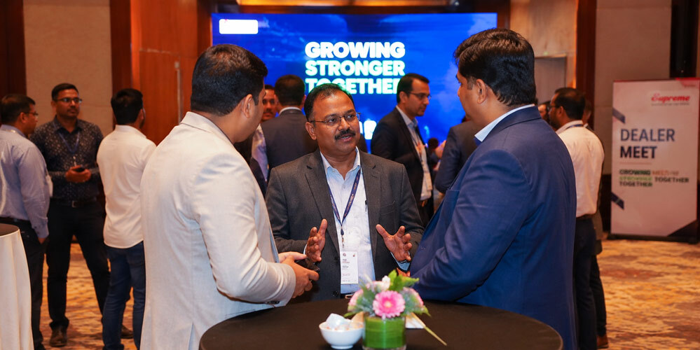 Corporate networking event photography capturing genuine business interactions and brand visibility moments at an Indian dealer meet shot for marketing assets