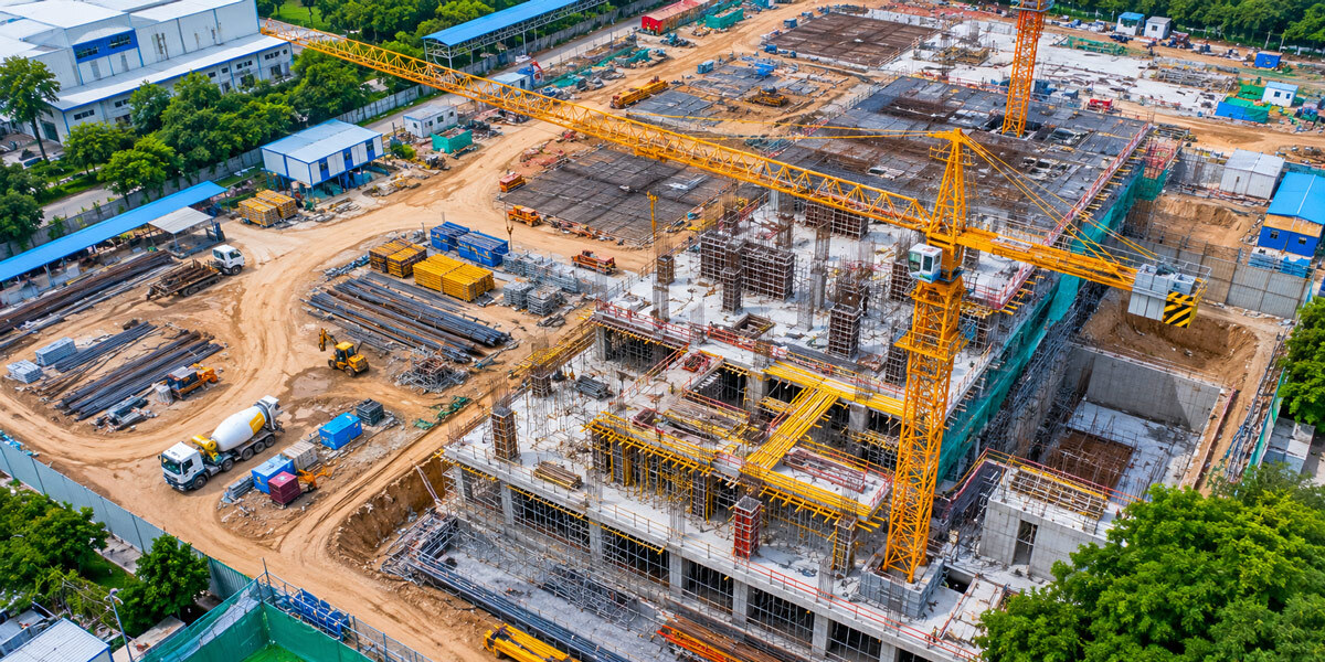 Top-down aerial drone view of a construction site in India showing crane positions material stockpiles and project progress for industrial project documentation portfolio