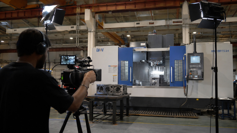 Professional cinematographer filming a CNC machine in operation inside an Indian manufacturing plant for an industrial process film