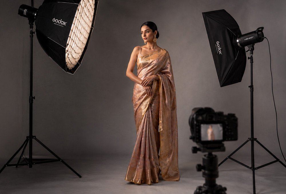 Editorial fashion photography setup in a Delhi studio with softbox lighting, model in silk ethnic wear, minimal grey backdrop, cinematic mood, high-end retouched image