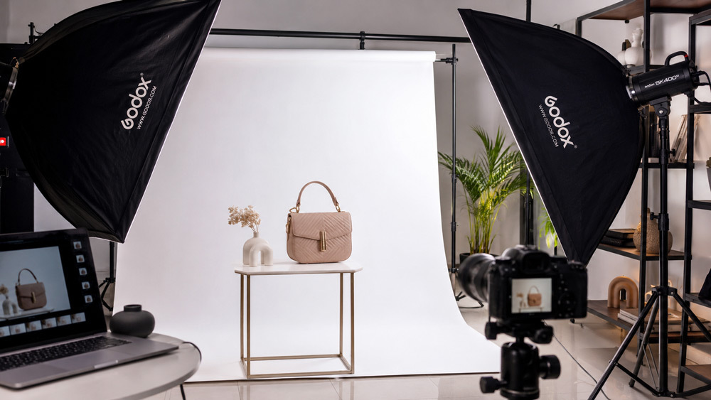 Professional product photography studio setup in Delhi NCR with softbox lighting and a styled product on a clean white sweep backdrop, editorial magazine aesthetic