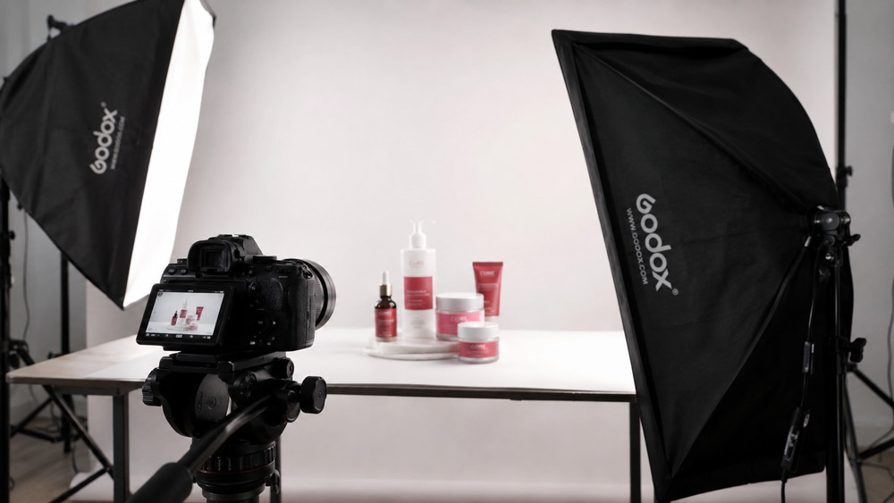 Professional ecommerce product photography setup with softbox lighting and camera on tripod capturing skincare bottles on white background for Amazon and Flipkart listings by Ckstudio Delhi NCR