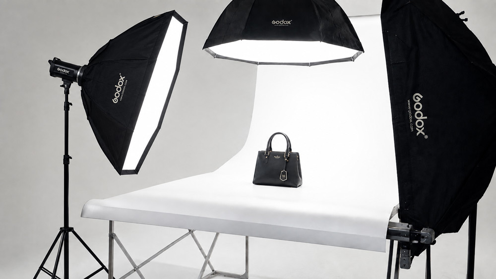 Ecommerce photography company studio setup with professional lighting, camera on tripod and premium product on white background for Amazon and Flipkart listings