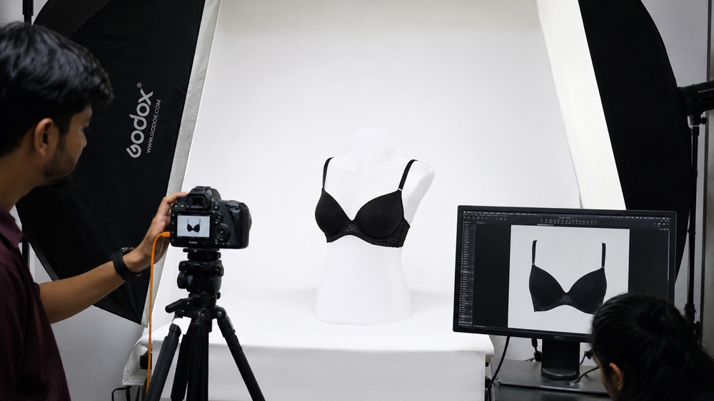 Ghost mannequin photography of a black underwired bra on invisible mannequin with soft cup fillers and clean white background at Indian standard ecommerce photography studio, showing structured cup shape and delicate lace trim for Amazon India primary catalogue image