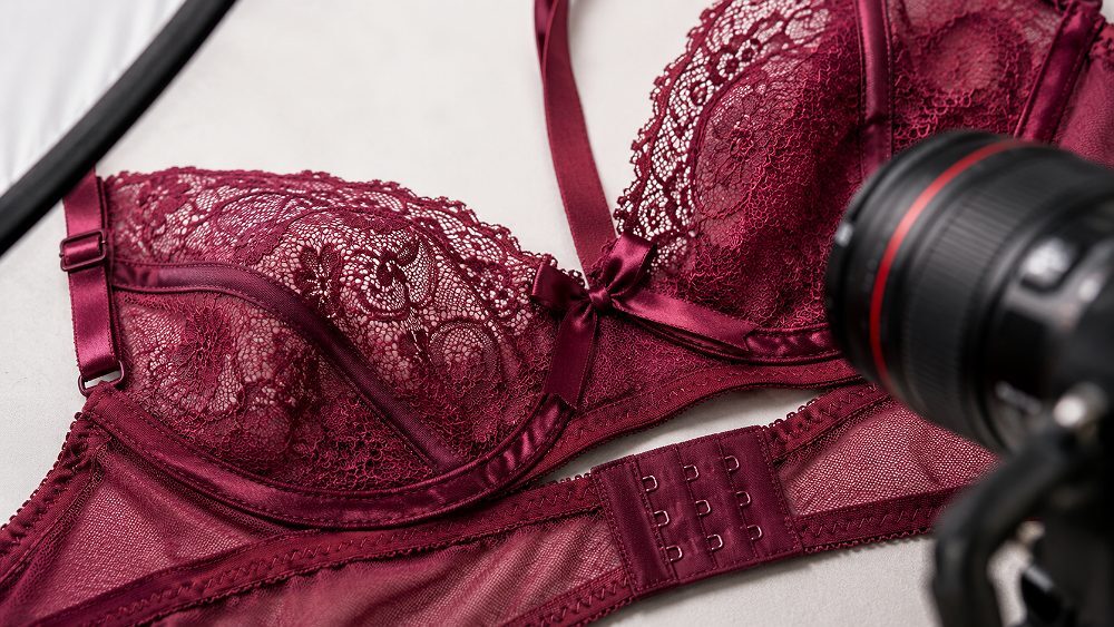 Behind the scenes of macro close-up lingerie product photography frame showing lace pattern texture, satin binding,