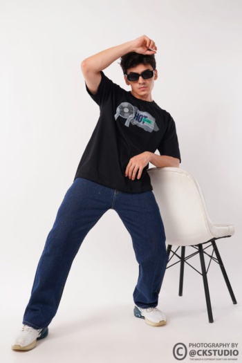 Shot of male model wearing black graphic t-shirt and blue jeans on white background — Ckstudio Commercial Product Photography