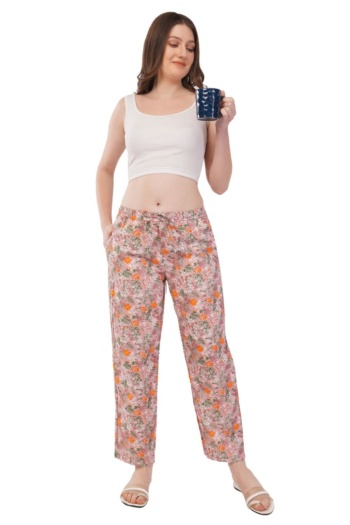 B) model wearing floral pants and white crop top, holding blue mug, shot on white background — Ckstudio Commercial Product Photography