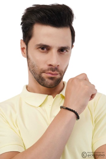 B) black beaded bracelet on wrist, man in yellow polo shirt, white background shot — Ckstudio, Jewellery Photography