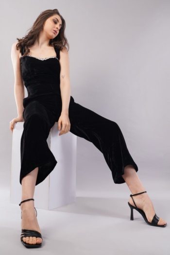 B) model wearing black velvet jumpsuit, seated on white cube, studio shot — Ckstudio; Commercial Product Photography