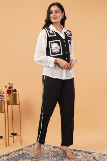 Shot of model wearing black and white embroidered vest and pants on beige background — Ckstudio Commercial Product Photography