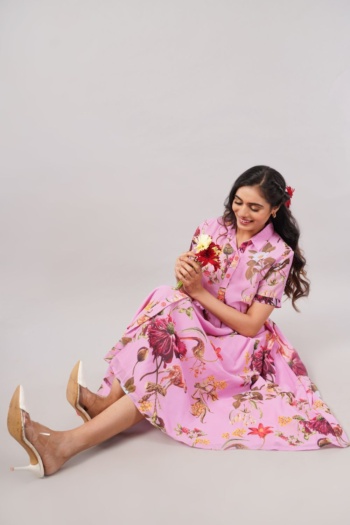 Ckstudio shot of model wearing floral pink dress sitting on light gray background, Fashion Photography