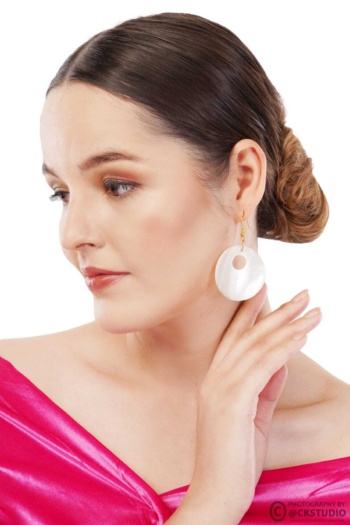 Shot of woman wearing white circular earrings on white background — Ckstudio Jewellery Photography