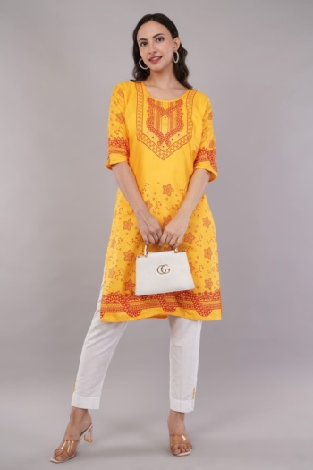 B model wearing yellow embroidered kurta with white pants and heels, shot on gray background, Commercial Product Photography — Ckstudio