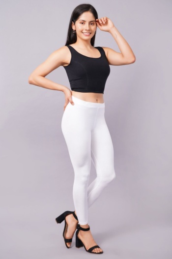 B) model wearing black crop top and white leggings, shot on light gray background, Commercial Product Photography — Ckstudio