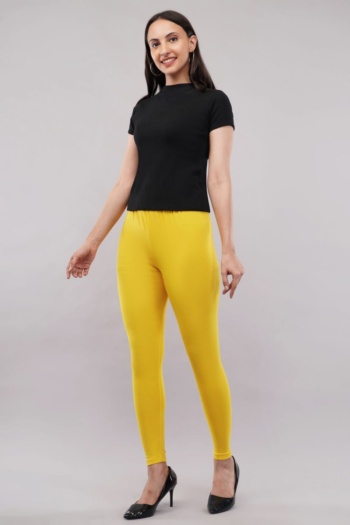 Shot of model wearing black top and yellow leggings on gray background — Ckstudio, Commercial Product Photography
