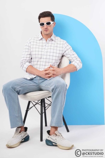 Shot of man wearing checkered shirt and jeans on white and blue background — Ckstudio Fashion Photography