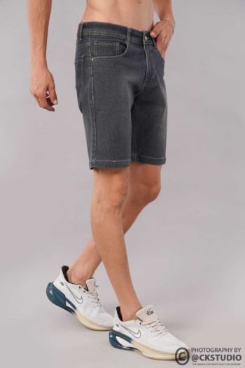Ckstudio shot of male model wearing denim shorts on plain gray background — Fashion Photography