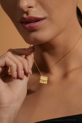 B) gold pendant necklace on model's neck, warm beige background, Jewellery Photography shot — Ckstudio