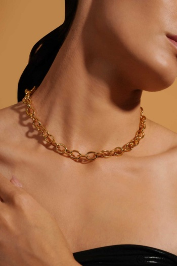 A shot of gold chain necklace on skin with warm brown background — Ckstudio Jewellery Photography