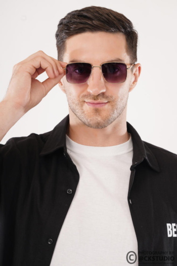 Ckstudio shot of a man adjusting sunglasses against a clean white background — Commercial Product Photography.