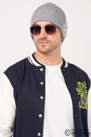 Ckstudio shot of a model wearing a beanie and sunglasses against a clean white background — Commercial Product Photography.