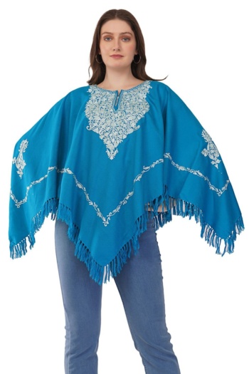 B) model wearing blue embroidered poncho, shot on white background — Ckstudio, Fashion Photography