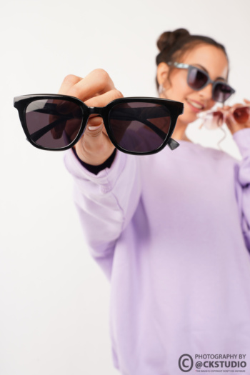 Ckstudio shot of woman holding sunglasses on white background — Commercial Product Photography